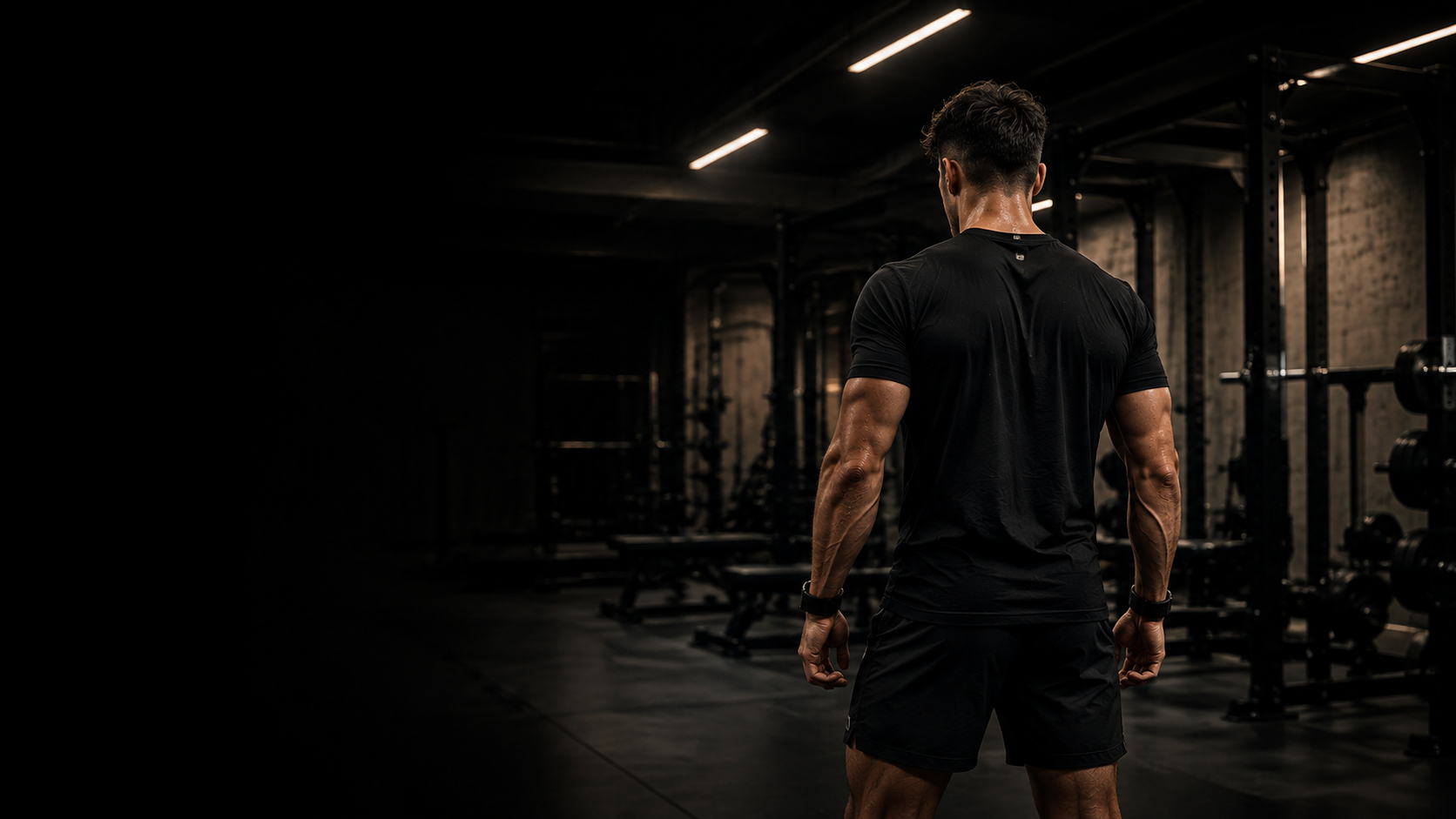 Athlete preparing to train in a dark premium gym